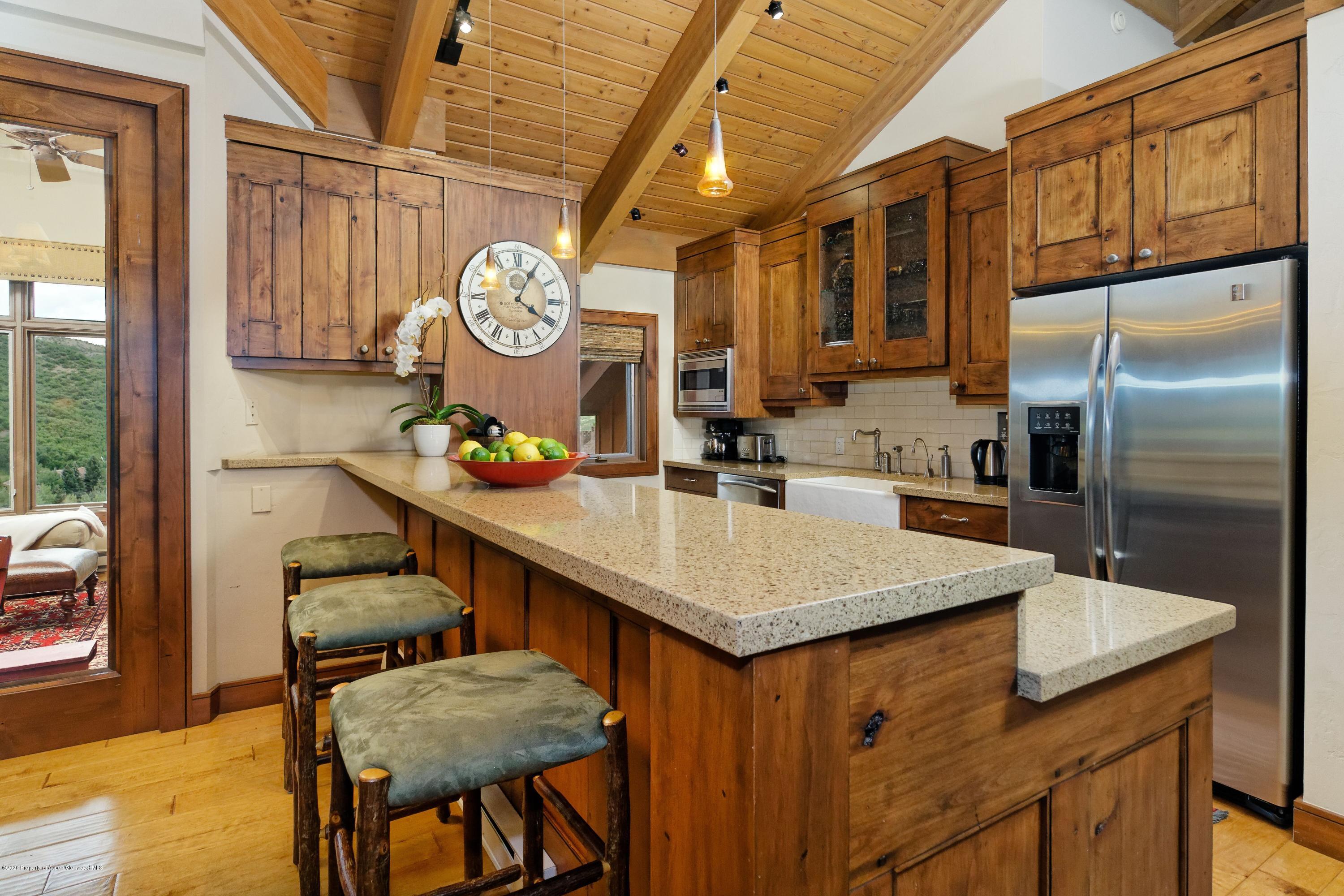 800 Ridge Road, Unit 14 Snowmass Village, CO 81615 - Photo 5 of 20 a kitchen with stainless steel appliances granite countertop a sink a stove and a refrigerator