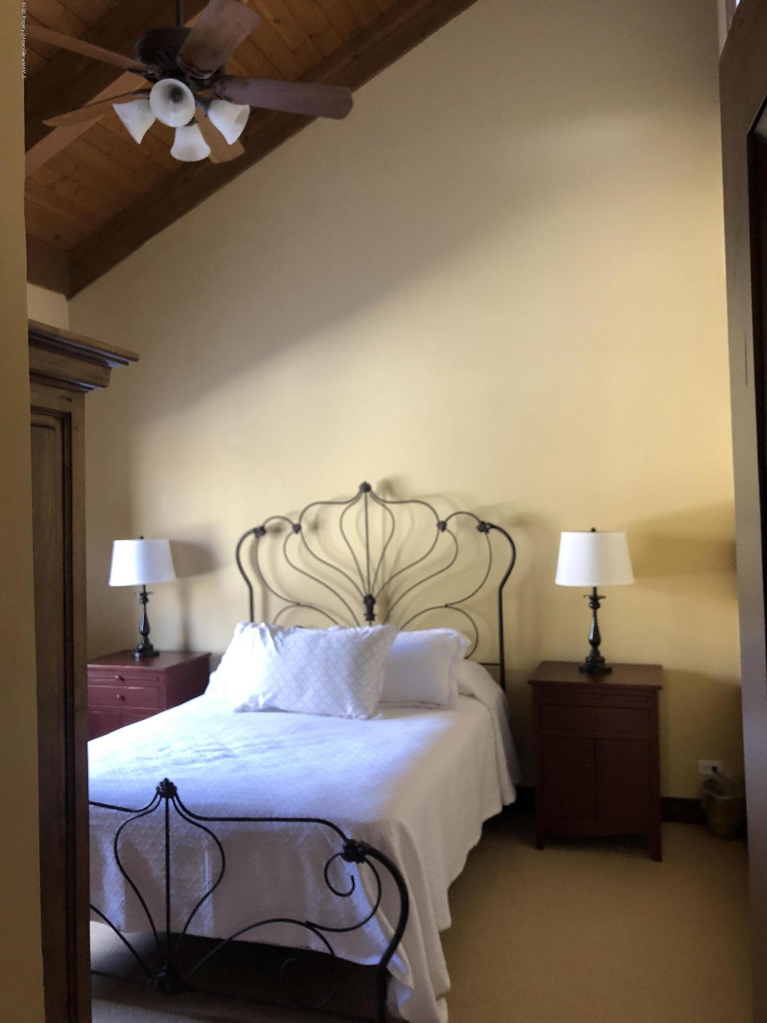 800 Ridge Road, Unit 14 Snowmass Village, CO 81615 - Photo 10 of 20 a bedroom with a bed and lamp