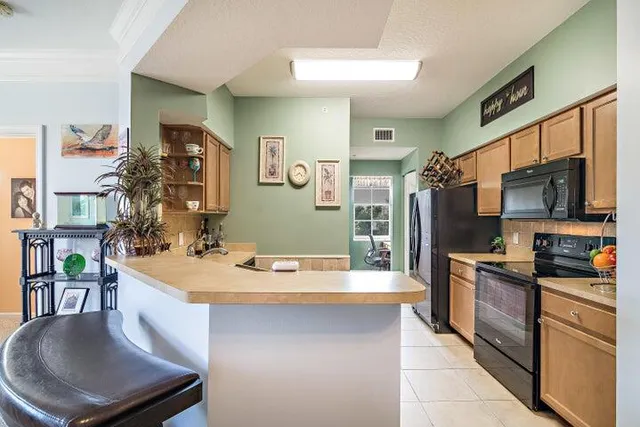 a kitchen with stainless steel appliances granite countertop a sink dishwasher stove refrigerator and microwave