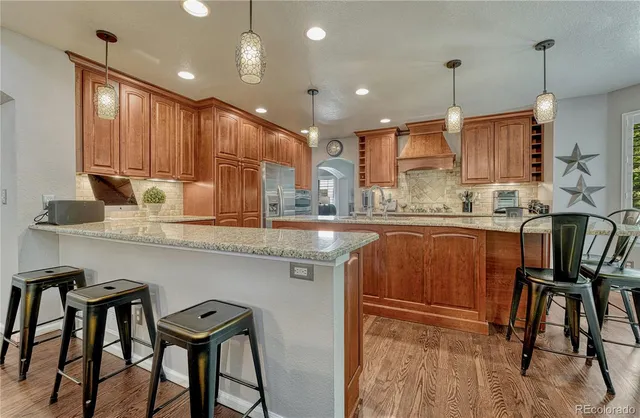 a kitchen with kitchen island granite countertop wooden cabinets and white appliances