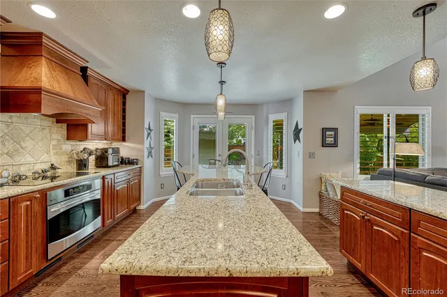 a large kitchen with stainless steel appliances granite countertop a stove and large cabinets