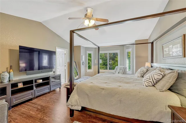 a bedroom with a bed and a flat tv screen on dresser