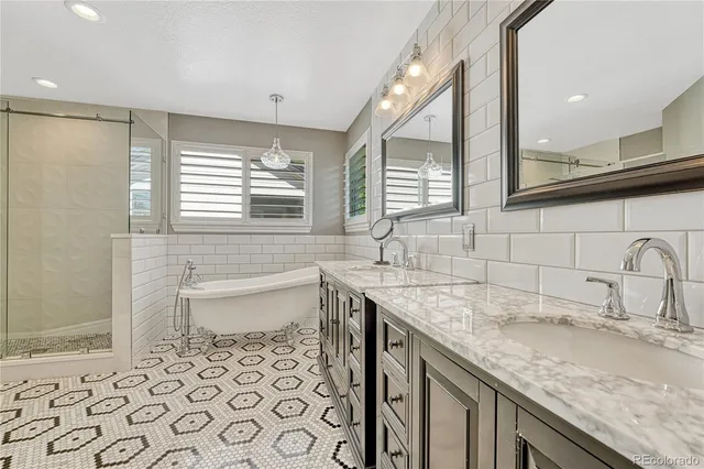 a bathroom with a granite countertop sink a toilet a mirror a vanity and shower