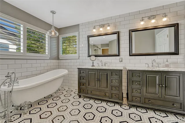 a bathroom with a double vanity sink mirror and bathtub