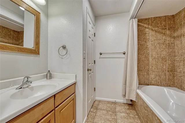 a bathroom with a tub sink and mirror