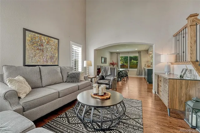 a living room with furniture a rug and a dining table