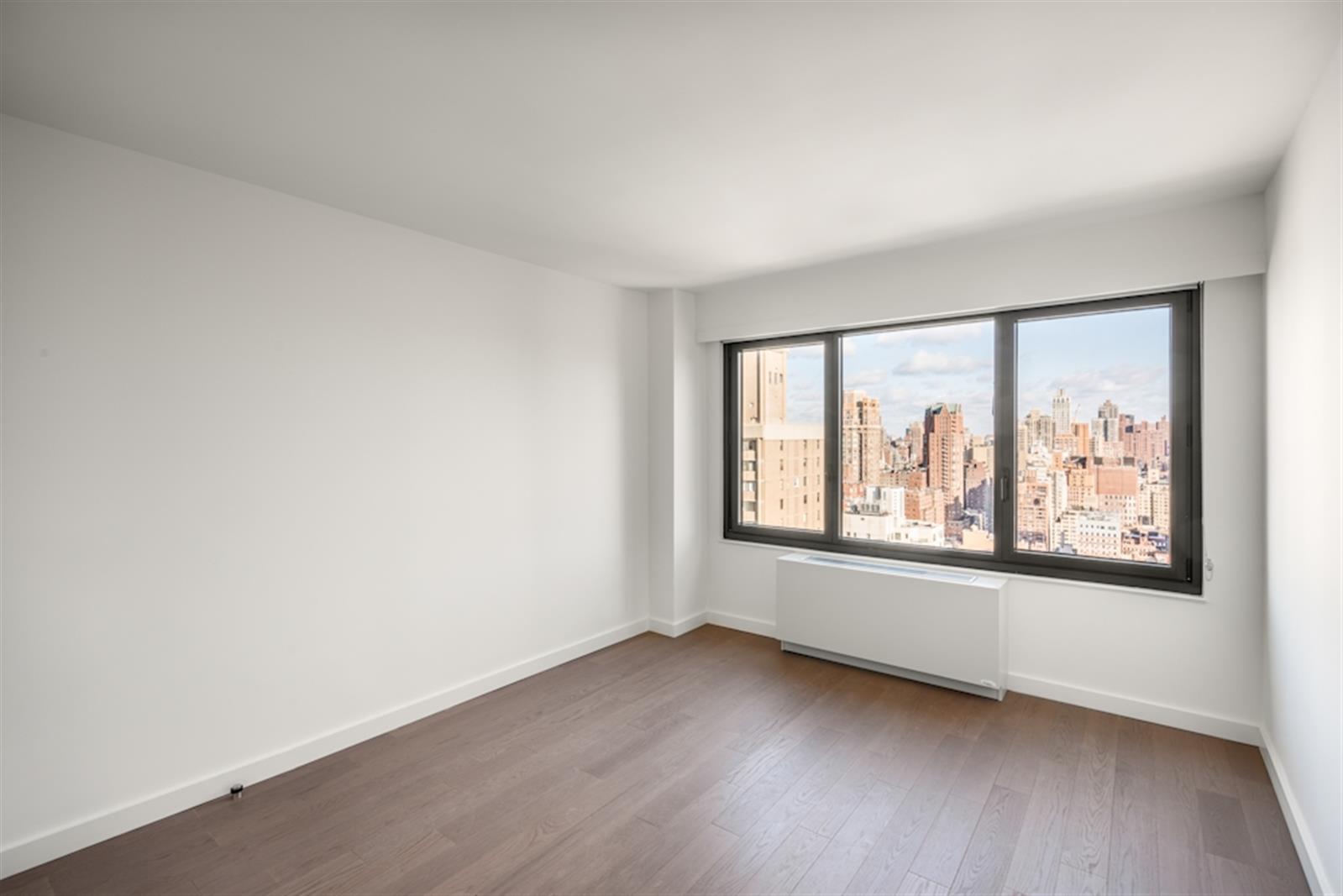 220 East 72nd Street, Unit 21E Manhattan, NY 10021 - Photo 3 of 11 an empty room with a window