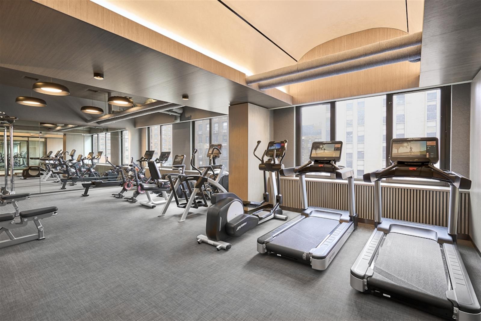 220 East 72nd Street, Unit 21E Manhattan, NY 10021 - Photo 10 of 11 a room with gym equipment and large mirror