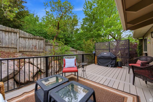 3674 Oak Rim Way Salt Lake City, UT 84109 - Photo 35 of 47 Spacious outdoor deck featuring composite flooring, black metal railings, a decorative privacy screen, and an adjacent retaining wall with natural rock elements