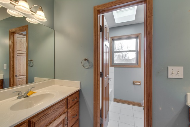 501 West Edgewood Road Lombard, IL 60148 - Photo 12 of 12 a bathroom with a sink a light fixture and a mirror