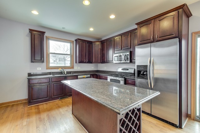 501 West Edgewood Road Lombard, IL 60148 - Photo 5 of 12 a kitchen with stainless steel appliances granite countertop a sink a stove window and refrigerator