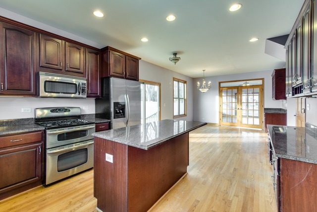 501 West Edgewood Road Lombard, IL 60148 - Photo 6 of 12 a kitchen with stainless steel appliances granite countertop a stove top oven a sink dishwasher a refrigerator and a cabinets with wooden floor