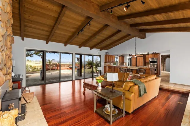 a living room with patio lots of furniture and wooden floor