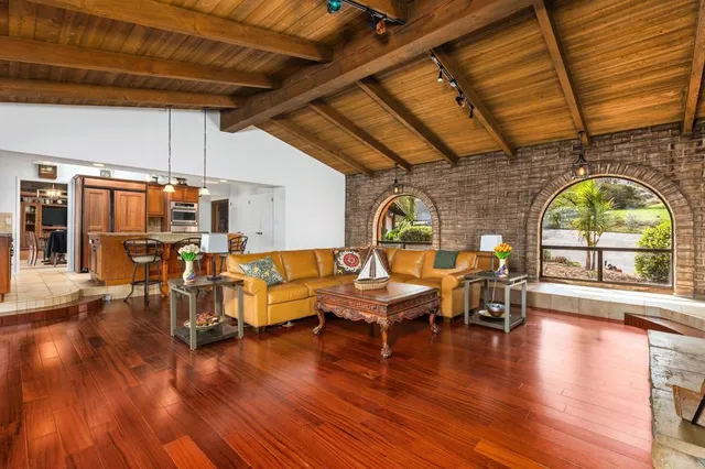 a living room with furniture a wooden floor and a large window