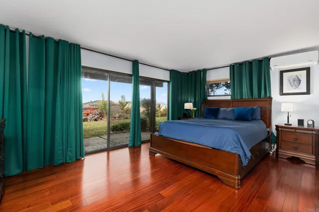 a spacious bedroom with a bed and a wooden floor