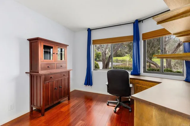 a view of a workspace with furniture and a window