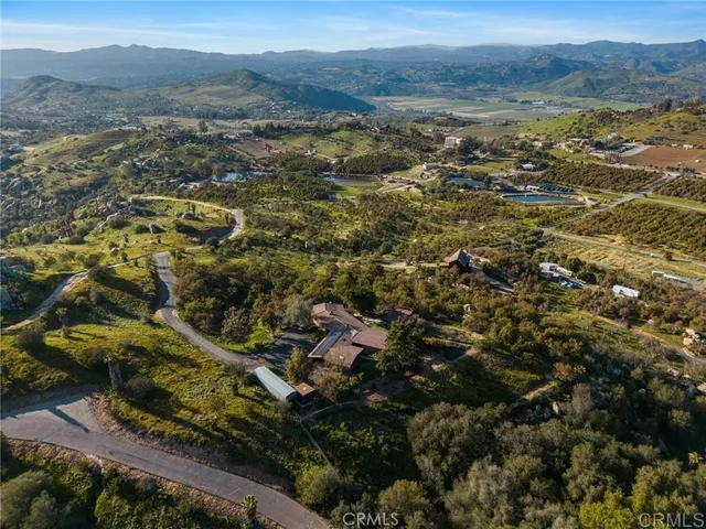 an aerial view of residential houses with outdoor space and trees