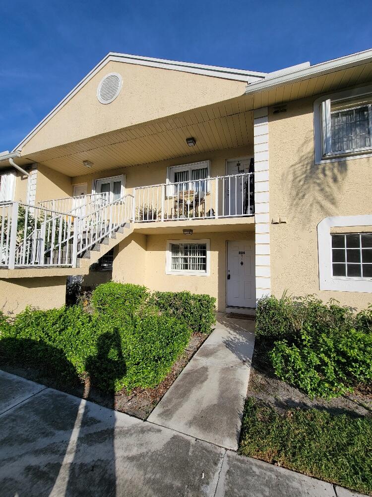 104 Palm Beach Trace Drive Royal Palm Beach, FL 33411 - Photo 1 of 16 a front view of a house with a yard