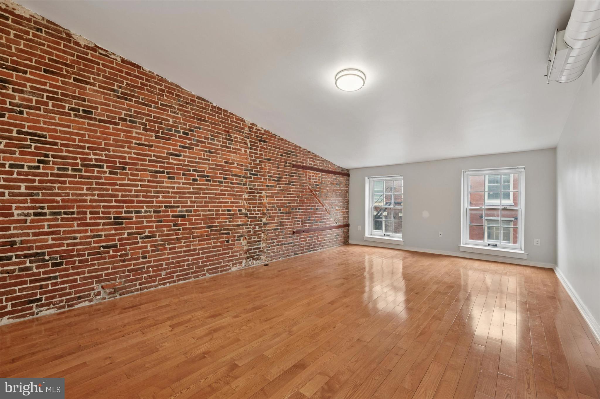 222 Church Street, Unit 2J Philadelphia, PA 19106 - Photo 14 of 17 a view of an empty room with wooden floor and a window