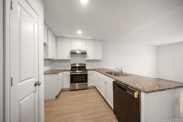 a kitchen with stainless steel appliances granite countertop a stove a sink and a refrigerator