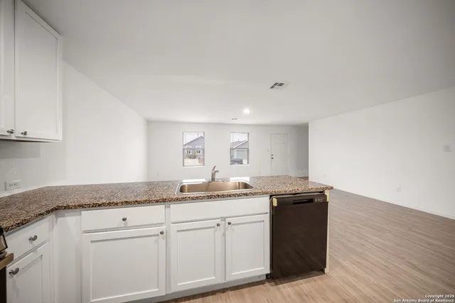 a utility room with granite countertop cabinets