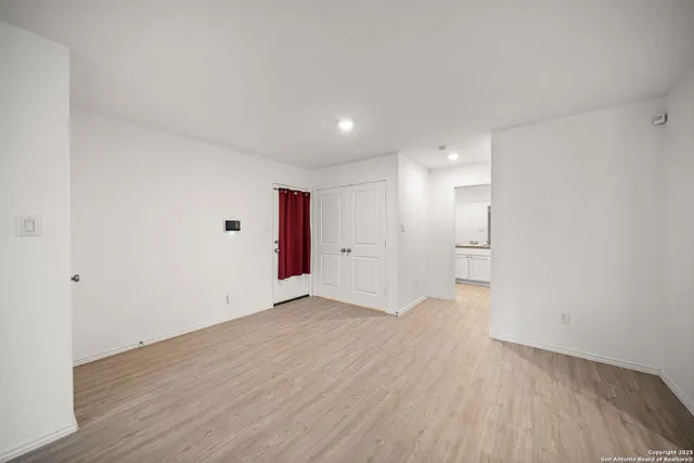 a view of an empty room with wooden floor