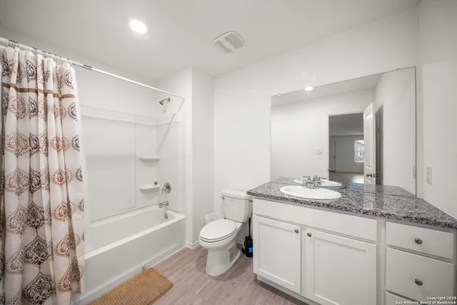 a bathroom with a granite countertop sink toilet tub and shower