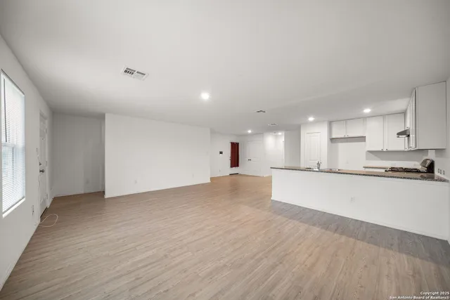 a large kitchen with stainless steel appliances granite countertop a large counter top and a wooden floors