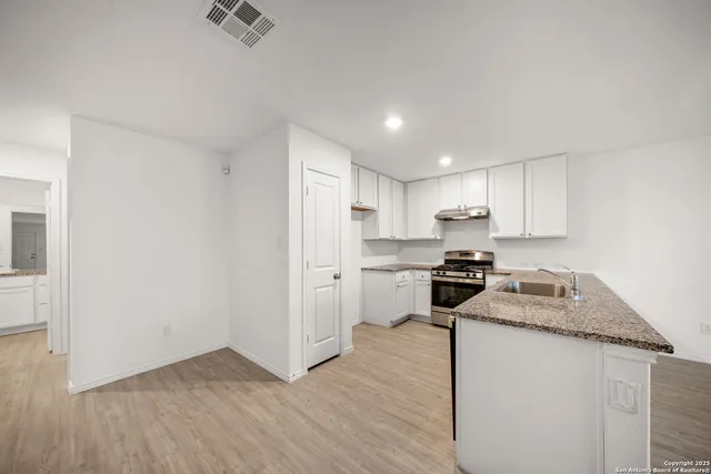 a kitchen with a refrigerator sink and cabinets