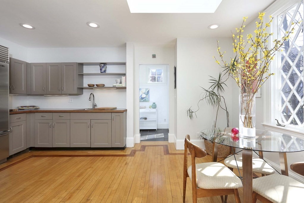 240 Clinton Road Brookline, MA 02445 - Photo 11 of 24 a kitchen with stainless steel appliances kitchen island granite countertop a table and chairs in it