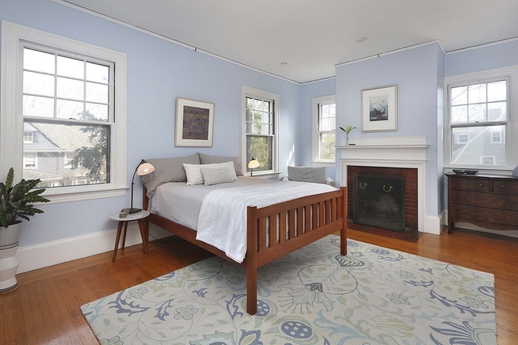240 Clinton Road Brookline, MA 02445 - Photo 16 of 24 a bedroom with a bed lamp and a fireplace