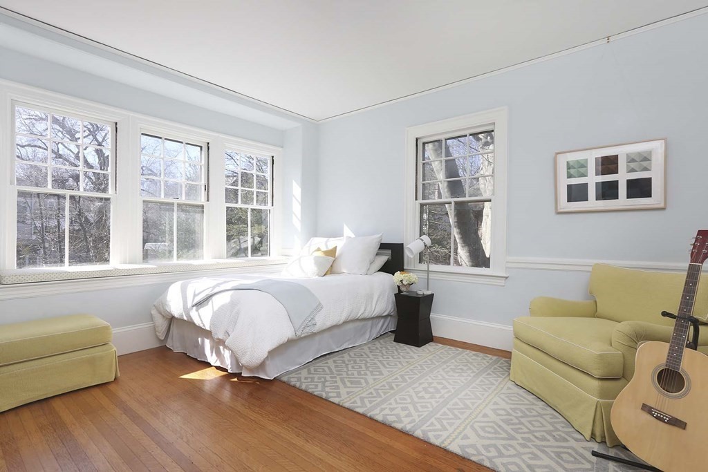 240 Clinton Road Brookline, MA 02445 - Photo 17 of 24 a spacious bedroom with a bed couch and a large window
