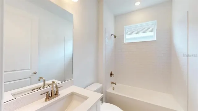 a bathroom with a tub sink toilet and a mirror