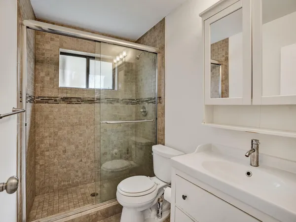 a bathroom with a sink mirror toilet and shower