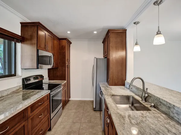 a kitchen with stainless steel appliances granite countertop a sink refrigerator and stove