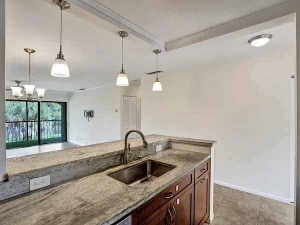 a kitchen with a sink a counter space and a window