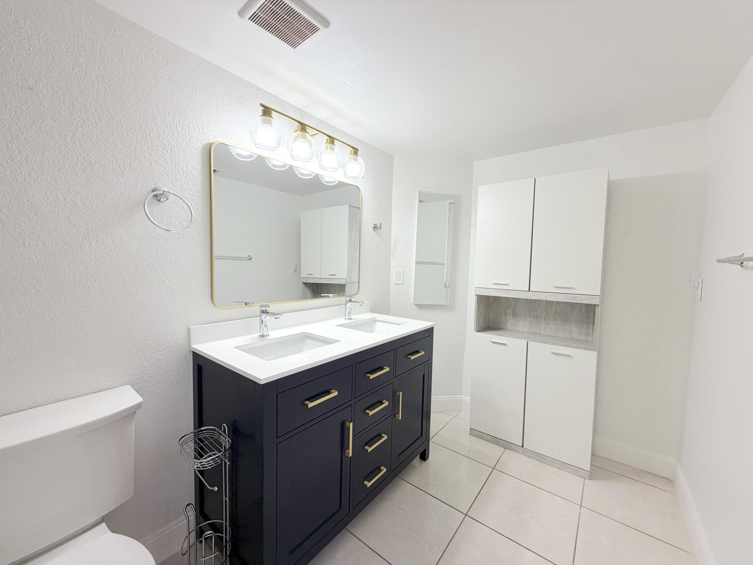 9927 Boca Gardens Trail, Unit A Boca Raton, FL 33496 - Photo 11 of 63 a bathroom with a sink a toilet and a mirror