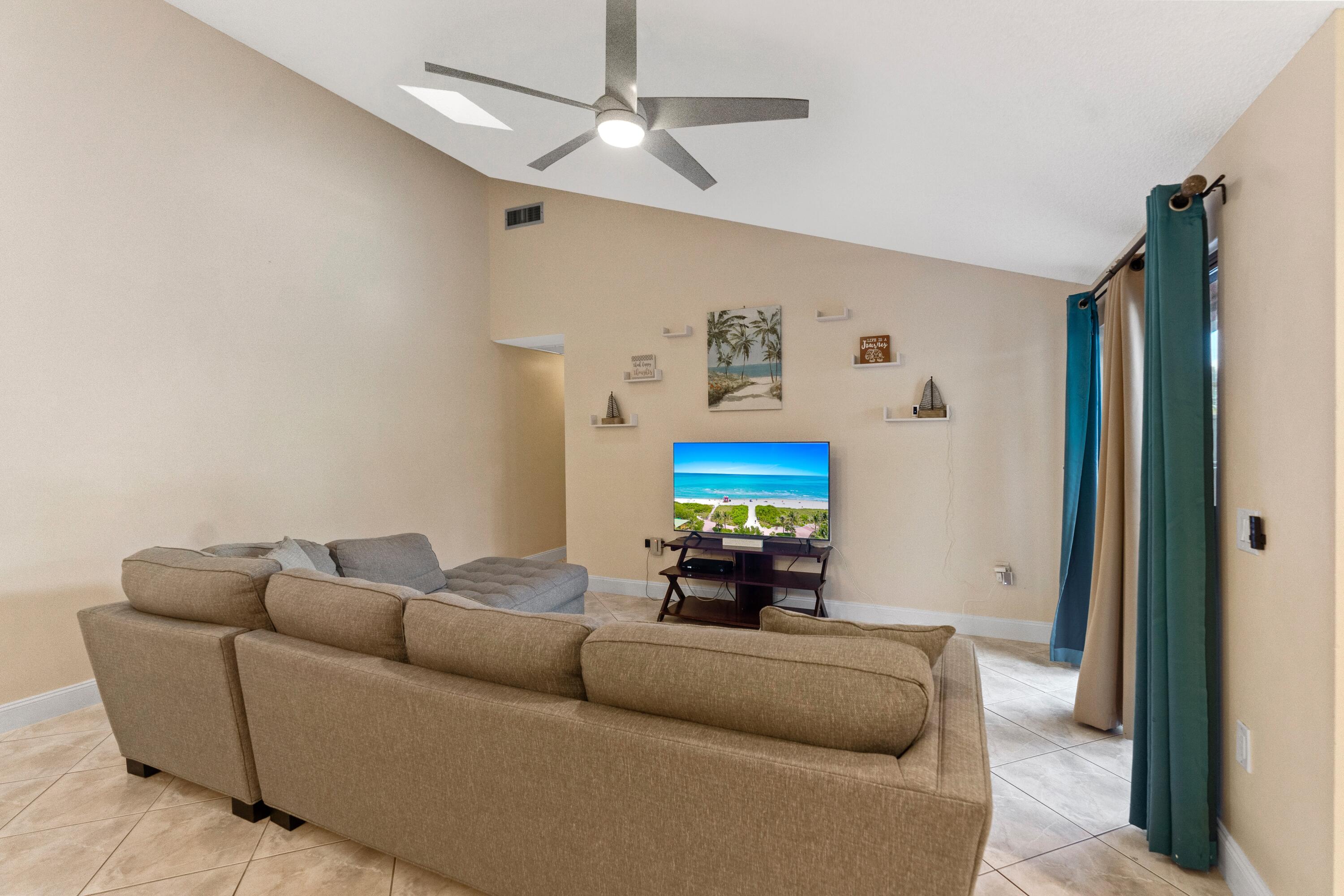 9927 Boca Gardens Trail, Unit A Boca Raton, FL 33496 - Photo 22 of 63 a living room with furniture and a flat screen tv