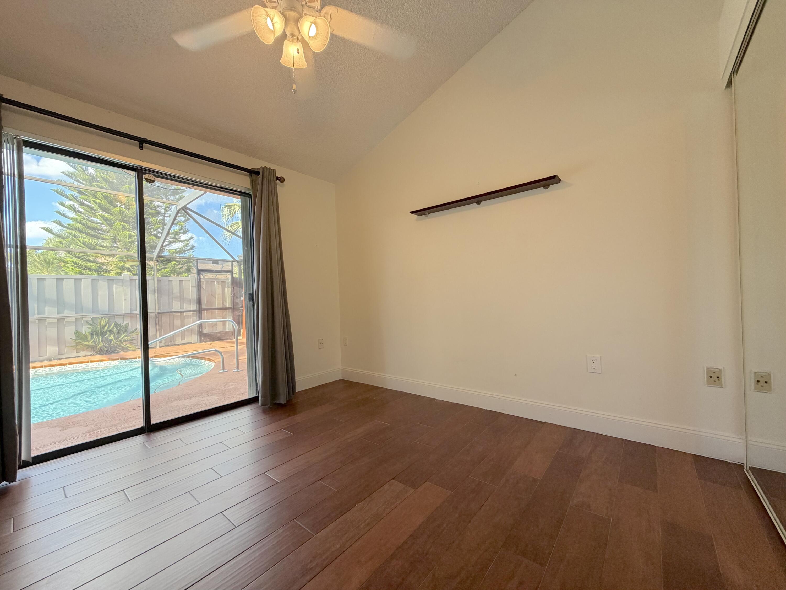 9927 Boca Gardens Trail, Unit A Boca Raton, FL 33496 - Photo 31 of 63 an empty room with wooden floor and windows