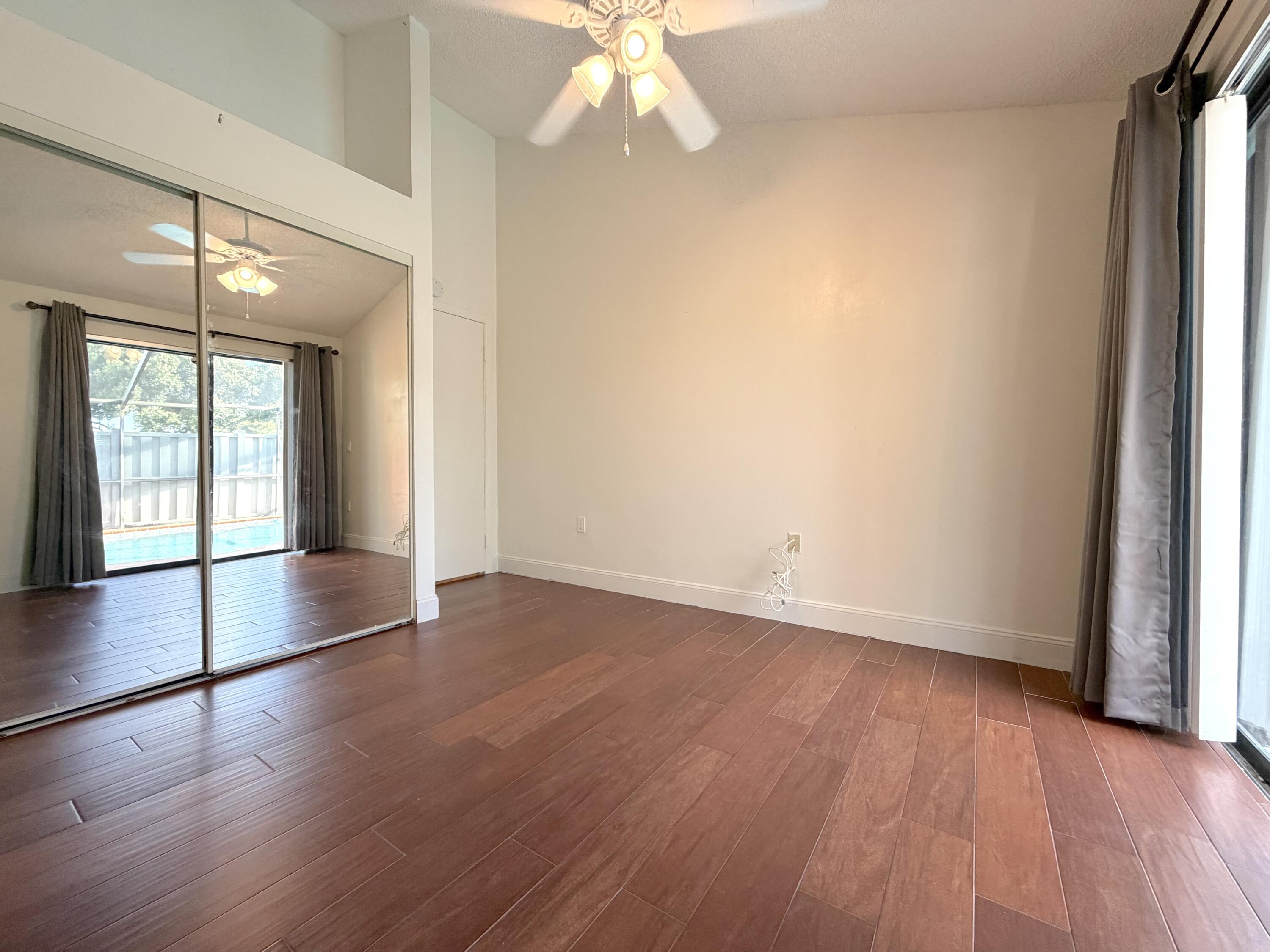 9927 Boca Gardens Trail, Unit A Boca Raton, FL 33496 - Photo 33 of 63 an empty room with wooden floor and windows