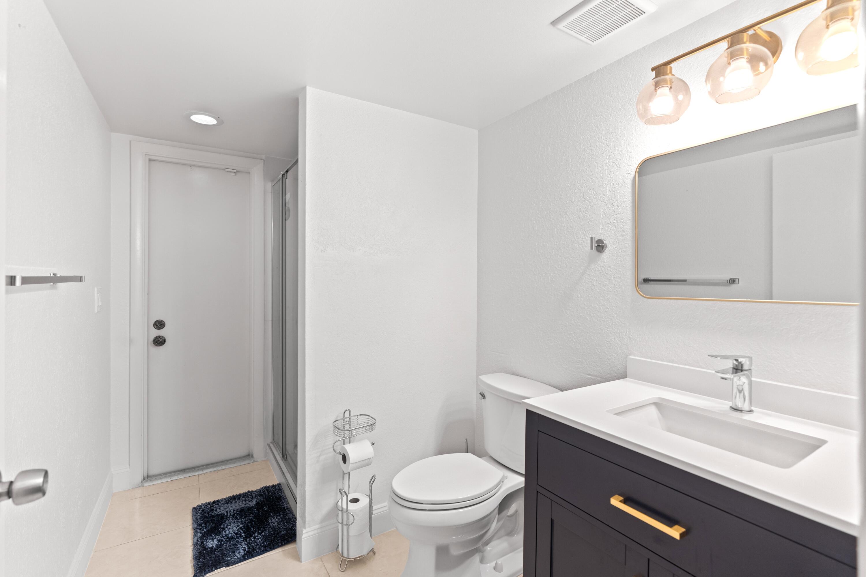 9927 Boca Gardens Trail, Unit A Boca Raton, FL 33496 - Photo 35 of 63 a bathroom with a sink a toilet and a mirror