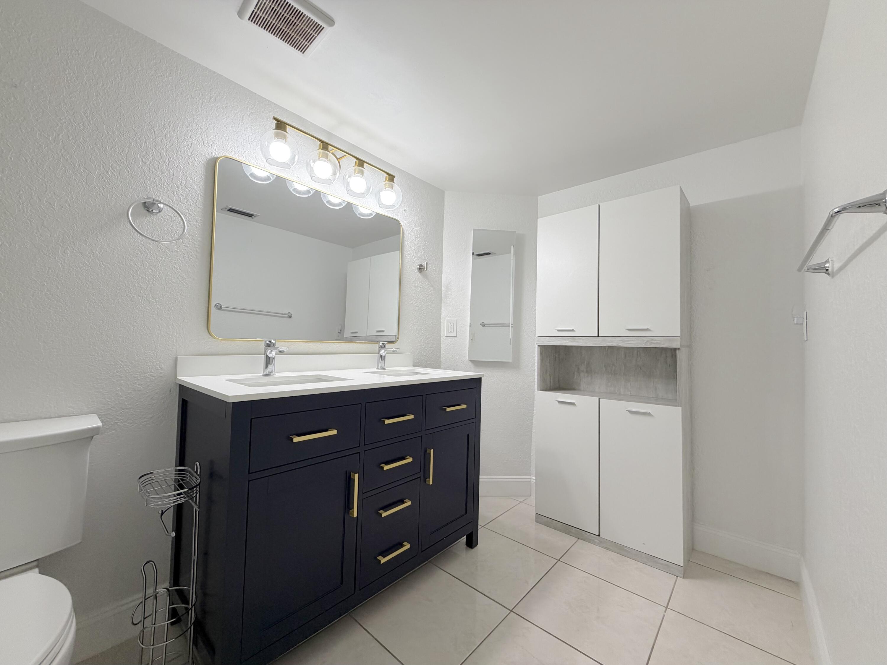 9927 Boca Gardens Trail, Unit A Boca Raton, FL 33496 - Photo 39 of 63 a bathroom with a sink vanity and mirror