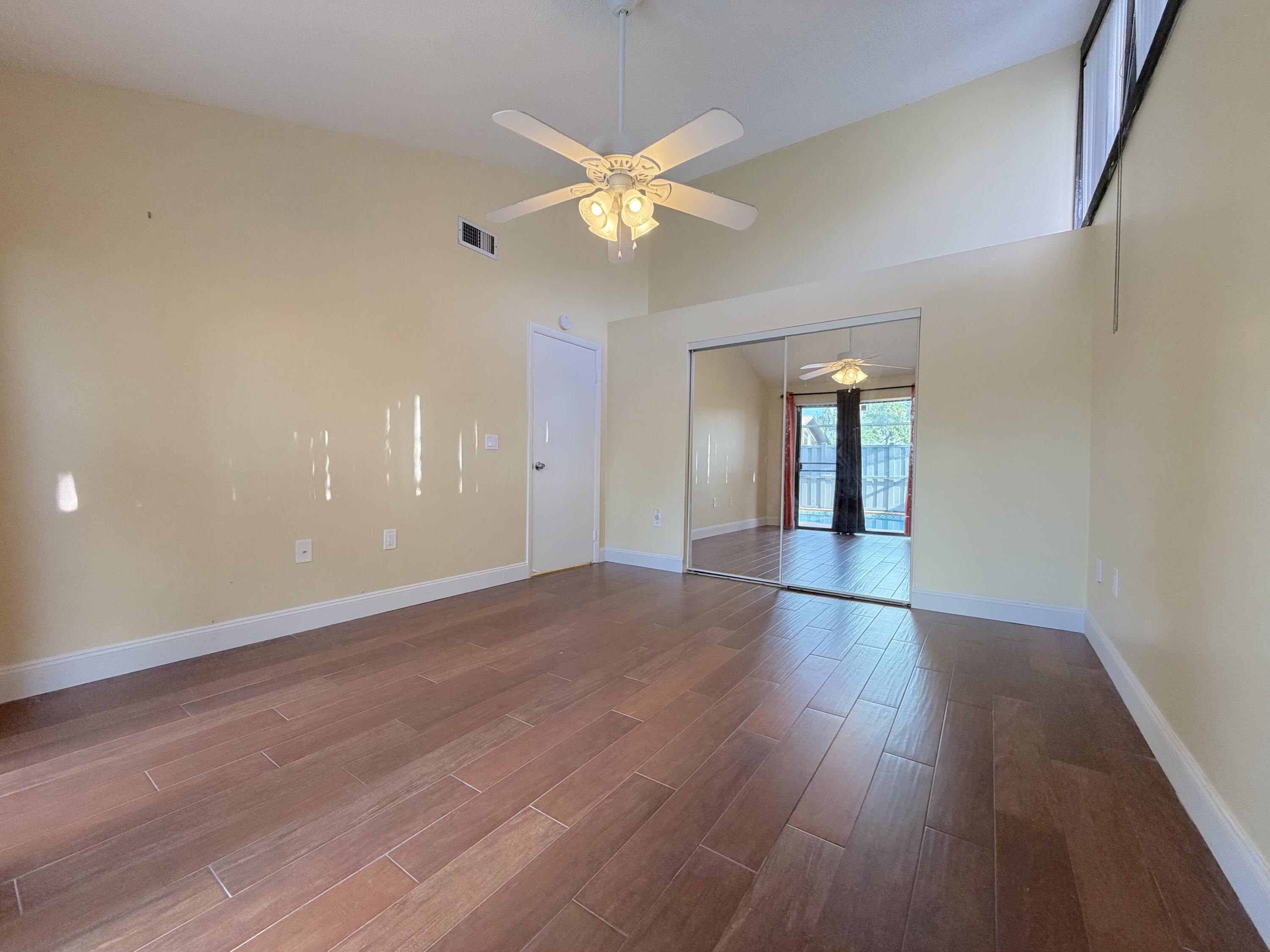9927 Boca Gardens Trail, Unit A Boca Raton, FL 33496 - Photo 46 of 63 a view of an empty room with window and wooden floor
