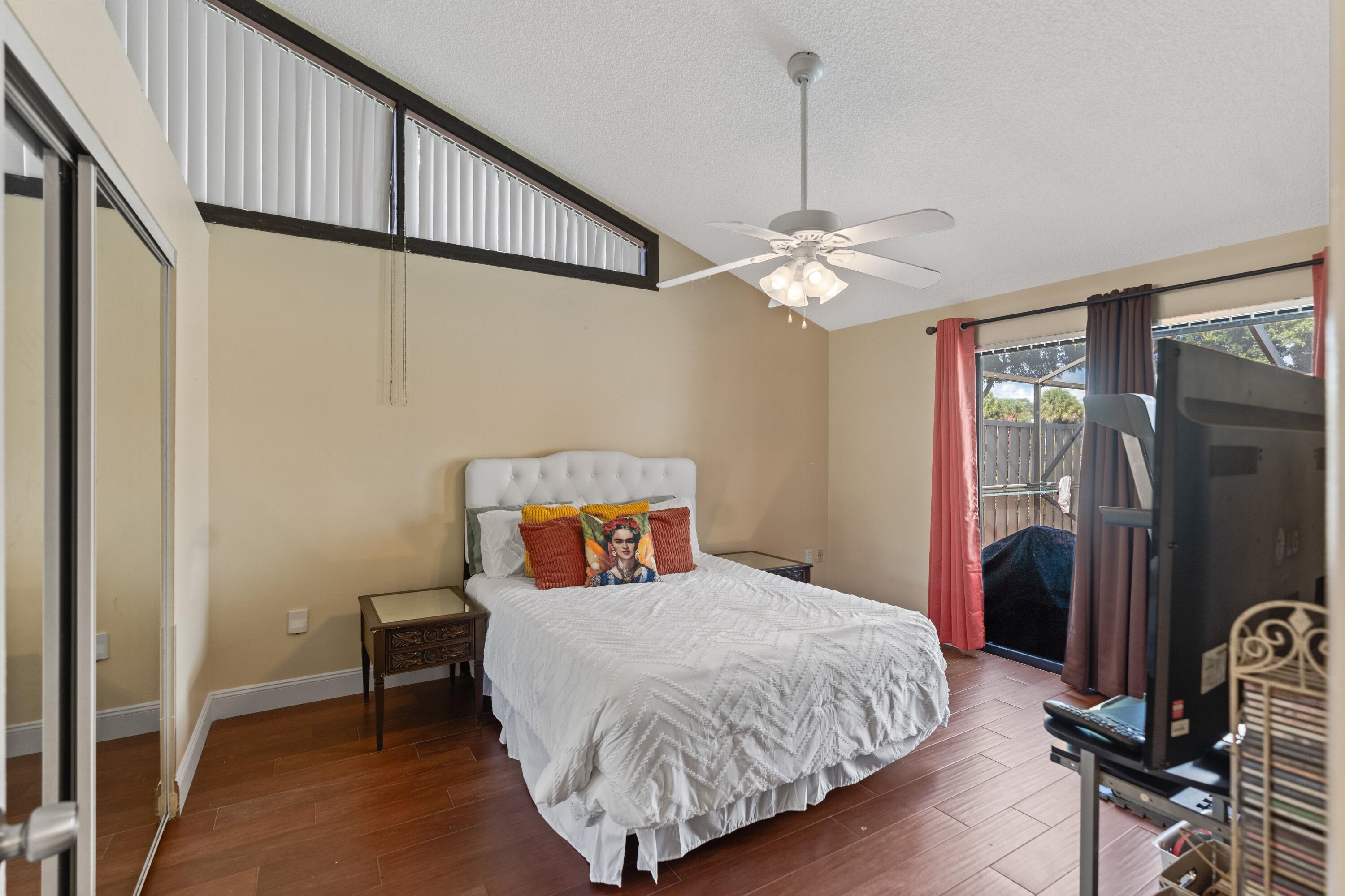 9927 Boca Gardens Trail, Unit A Boca Raton, FL 33496 - Photo 47 of 63 a bedroom with a bed and a chandelier