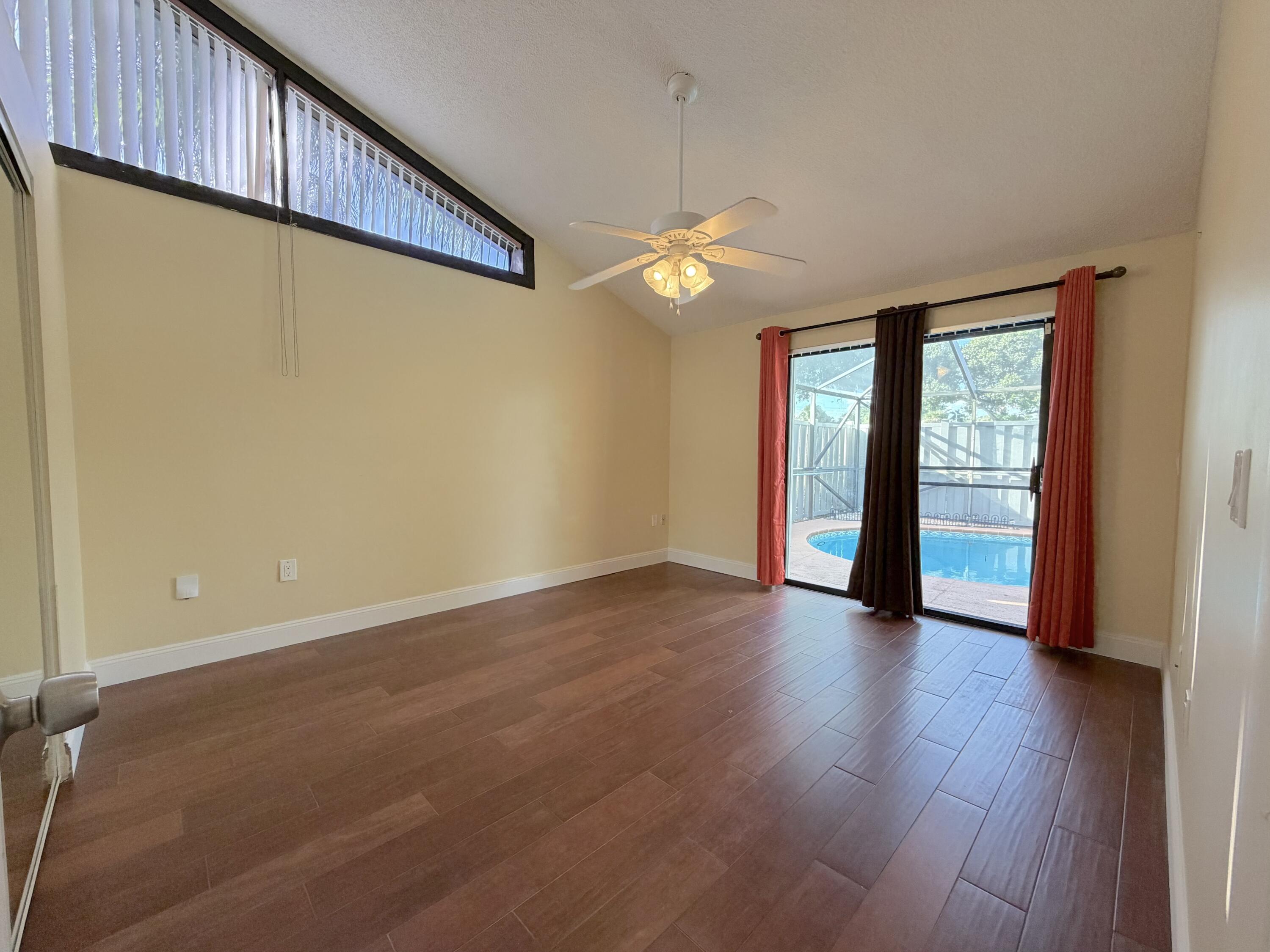 9927 Boca Gardens Trail, Unit A Boca Raton, FL 33496 - Photo 48 of 63 a view of an empty room with a window and wooden floor