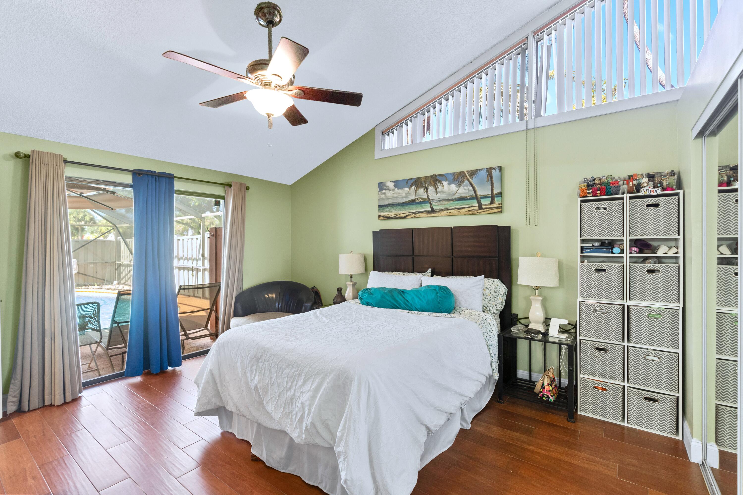 9927 Boca Gardens Trail, Unit A Boca Raton, FL 33496 - Photo 6 of 63 a bedroom with a large bed and a chandelier