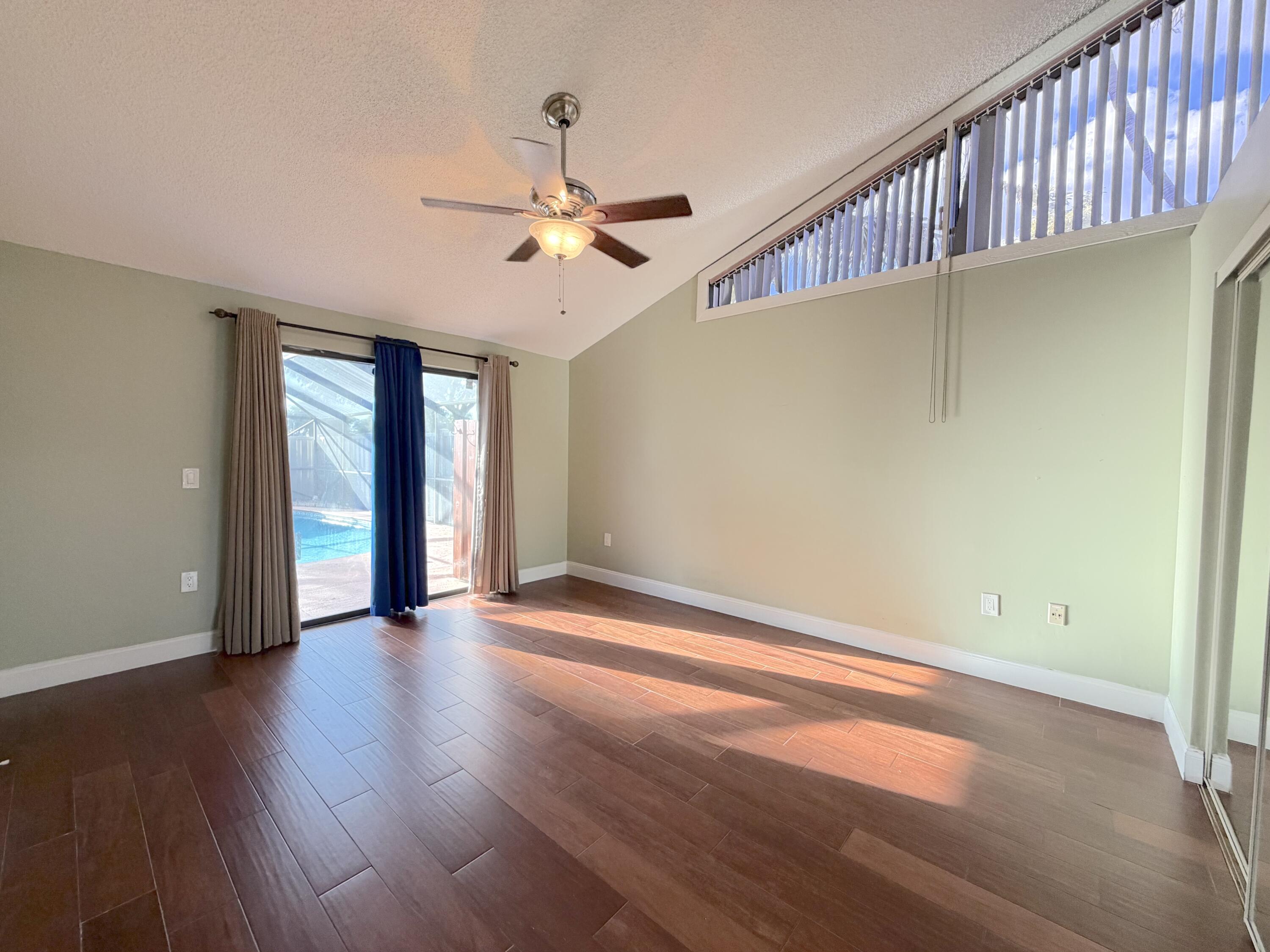 9927 Boca Gardens Trail, Unit A Boca Raton, FL 33496 - Photo 7 of 63 a view of an empty room with window and wooden floor
