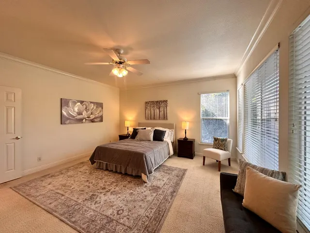a bedroom with a large bed and a chandelier
