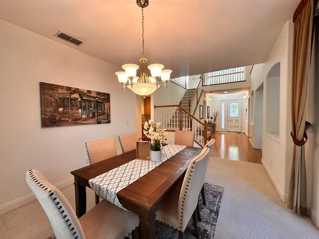a view of a dining room with furniture a chandelier and wooden floor
