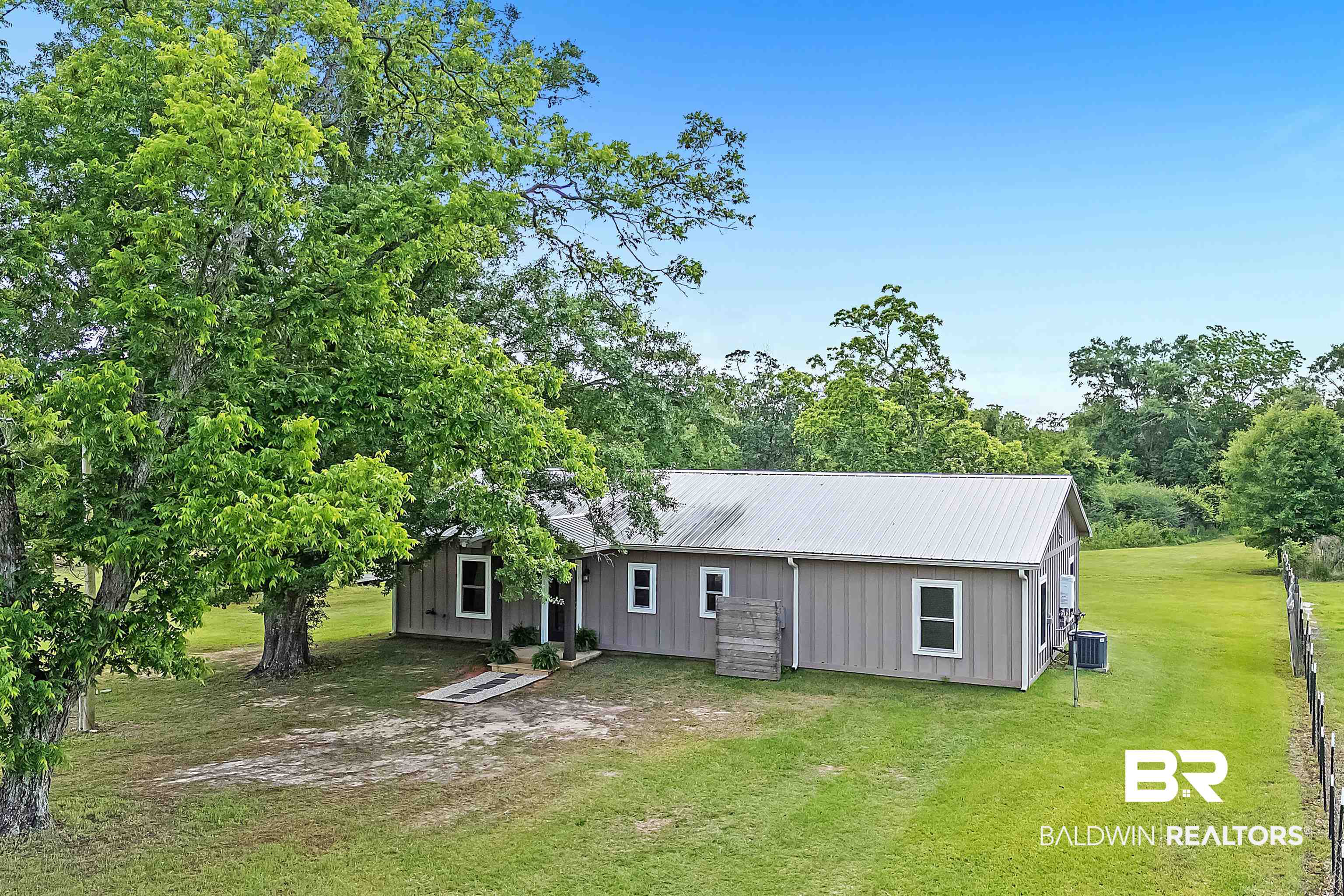 13827 County Road 83 Elberta, AL 36530 - Photo 38 of 38 Rear view of property with central air condition unit, a lawn, board and batten siding, and metal roof